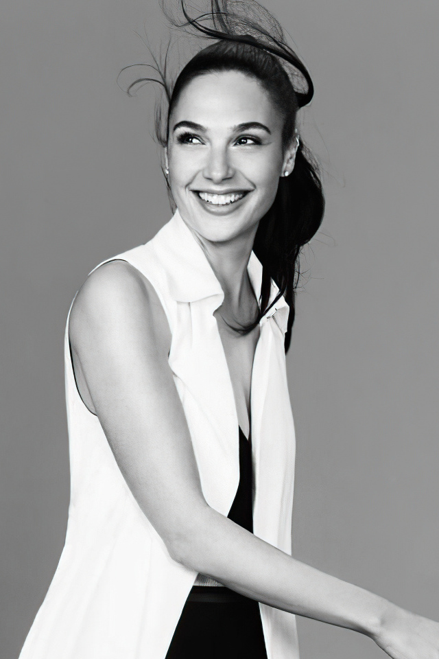 Улыбающаяся актриса Галь Гадот на сером фоне