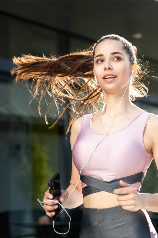 Спортивная девушка занимается бегом на улице