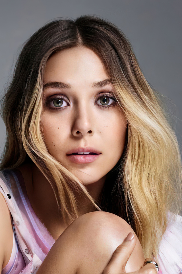 Удивленная девушка, актриса Элизабет Олсен на сером фоне