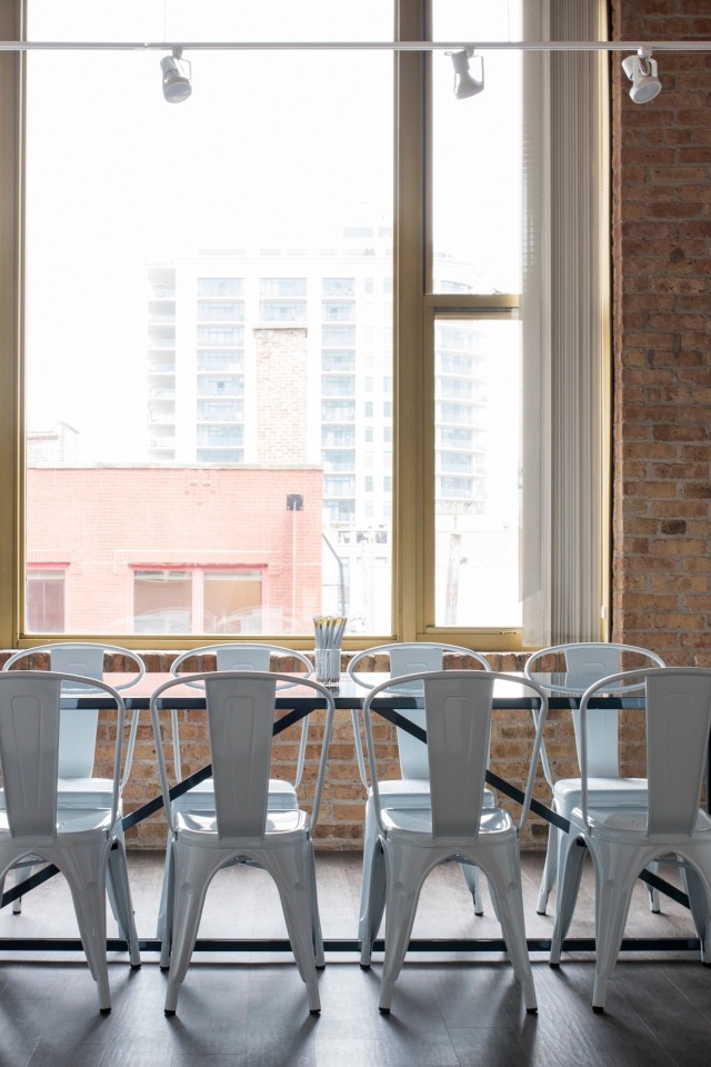 Стол с белыми стульями у большого окна на кухне 