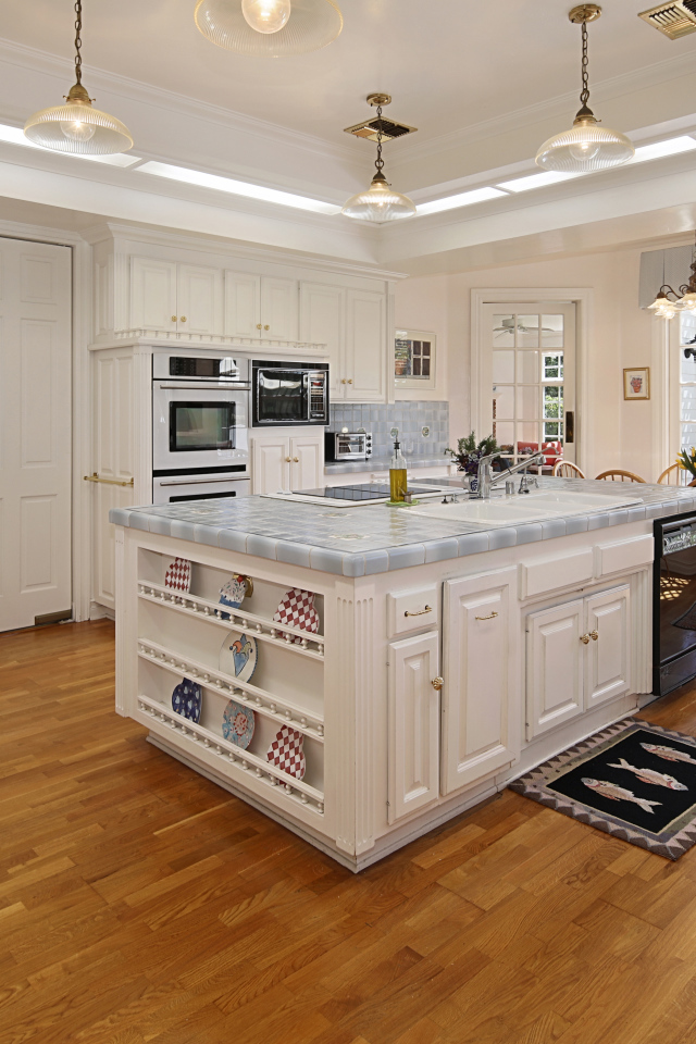 Белые стены и мебель на просторной современной кухне 