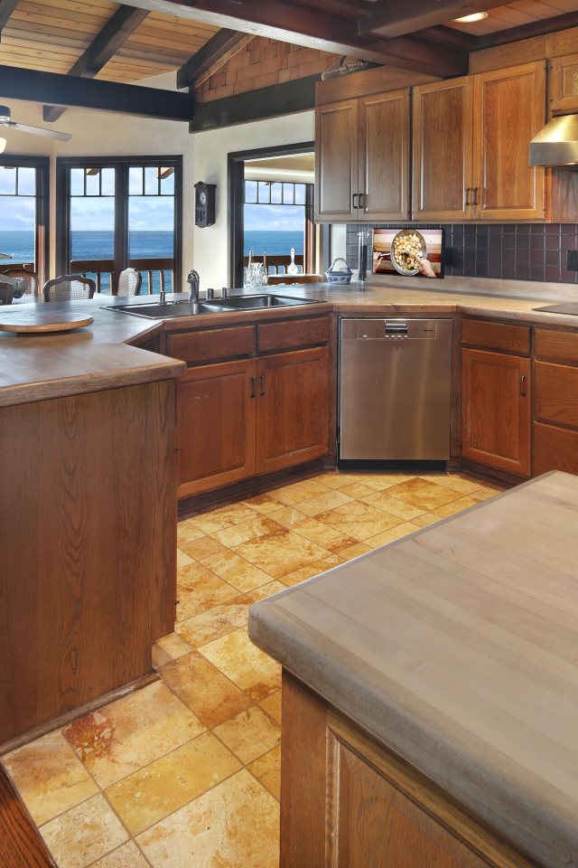Деревянная мебель на кухне с окнами с видом на море