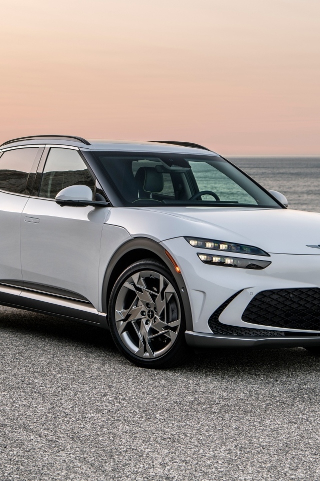 Белый автомобиль Genesis GV60, 2023 года на пляже