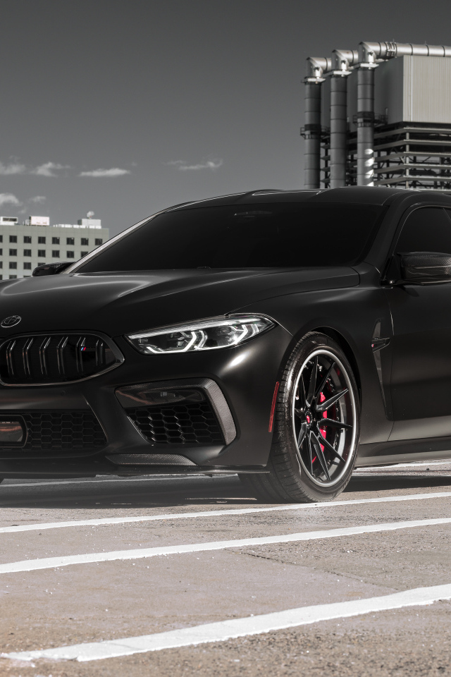 Черный автомобиль BMW M8 на стройке