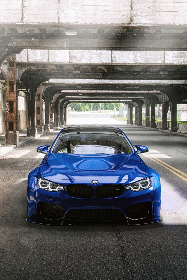 Синий автомобиль BMW M4 под мостом