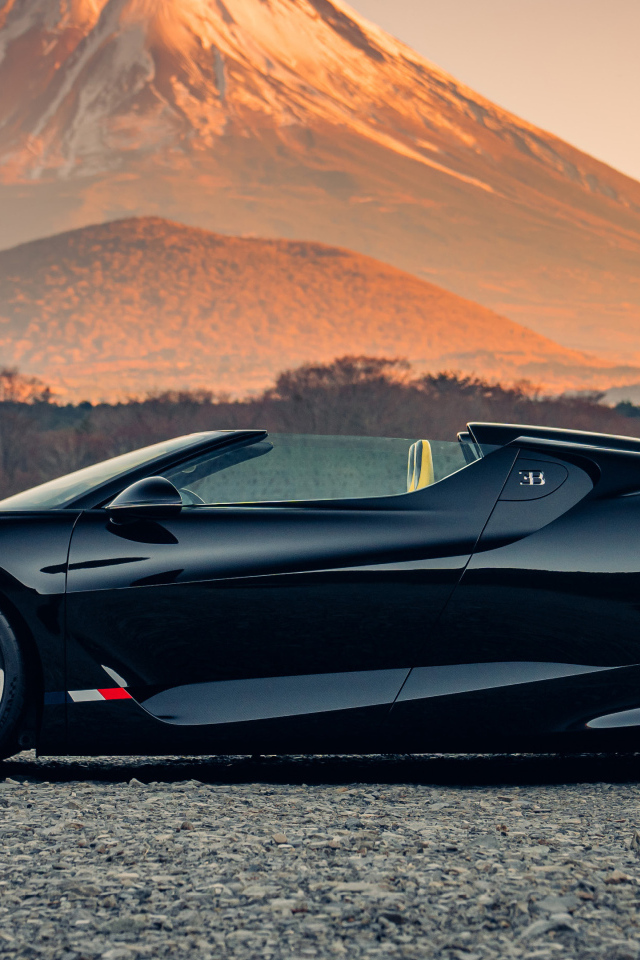 Черный автомобиль Bugatti W16 Mistral  на фоне горы