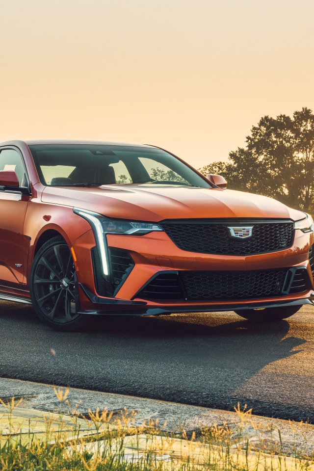 Красный Cadillac CT4-V на дороге на фоне солнца 