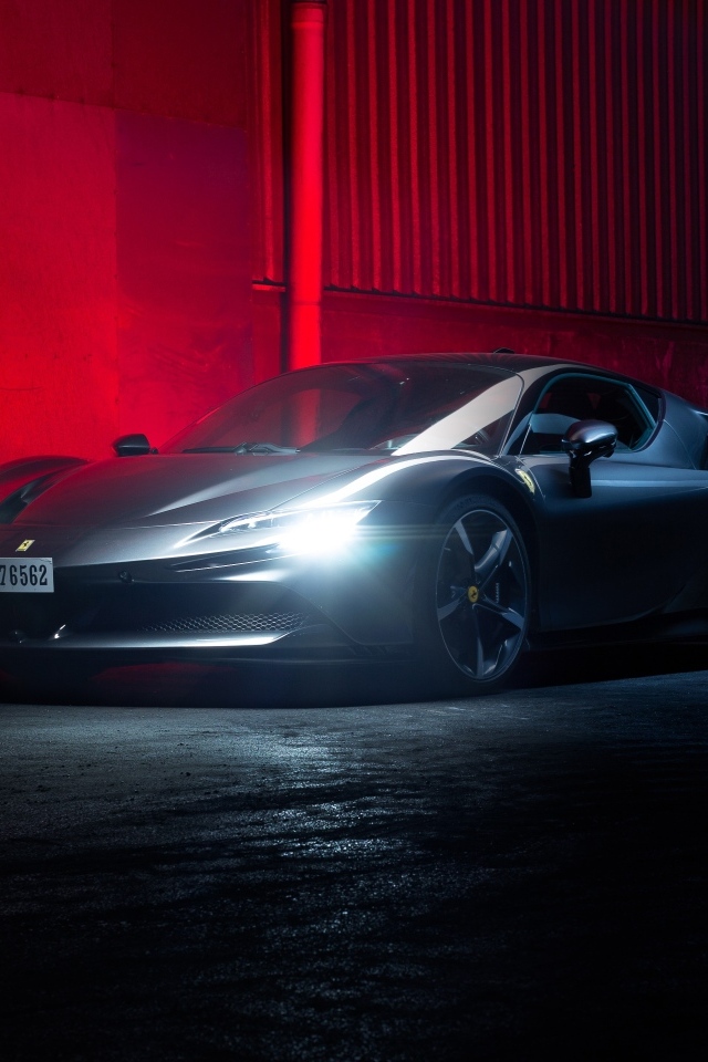 Автомобиль Ferrari SF90 Stradale с включенными фарами на красном фоне
