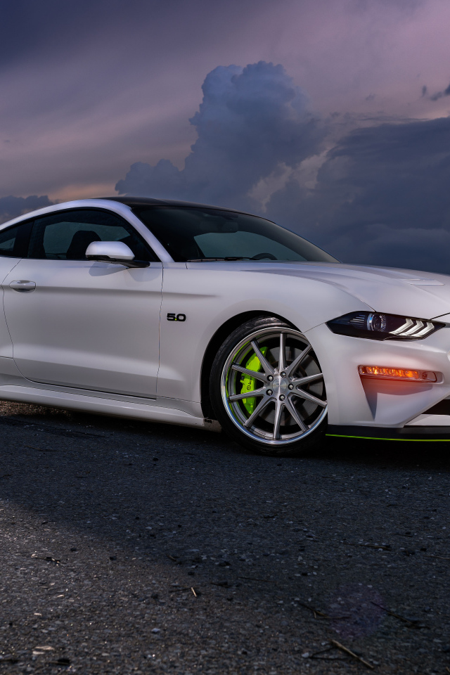 Белый автомобиль Ford Mustang GT на фоне неба