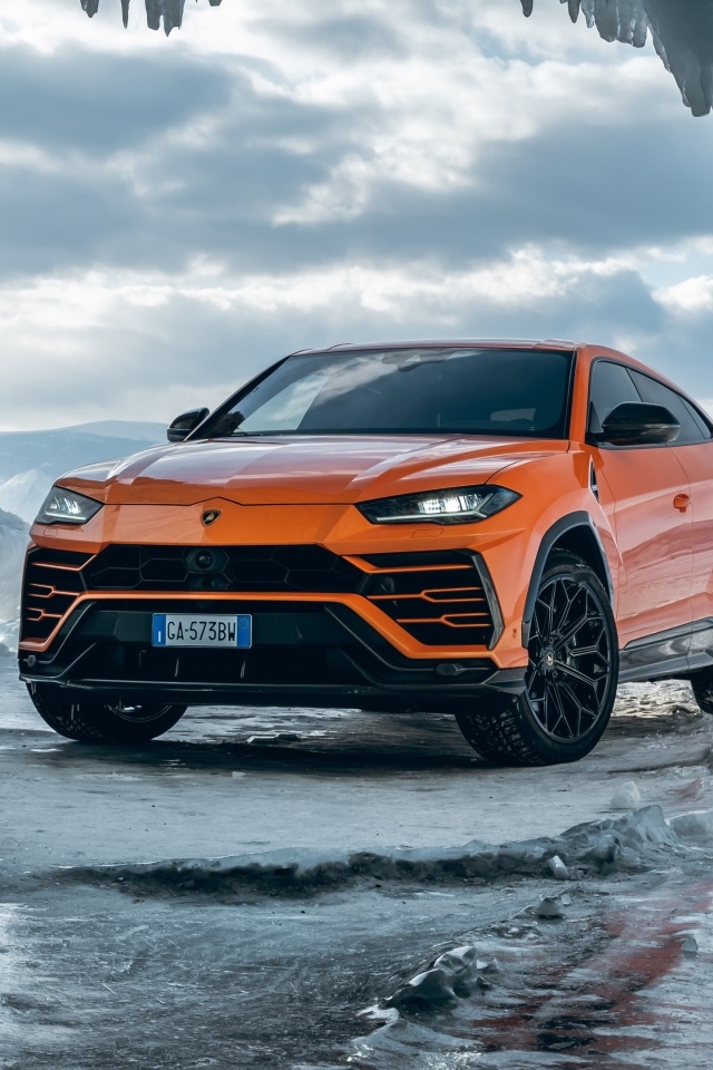 Оранжевый внедорожник Lamborghini Urus у ледяной пещеры
