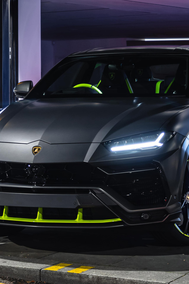 Серебристый Lamborghini Urus с включенными фарами