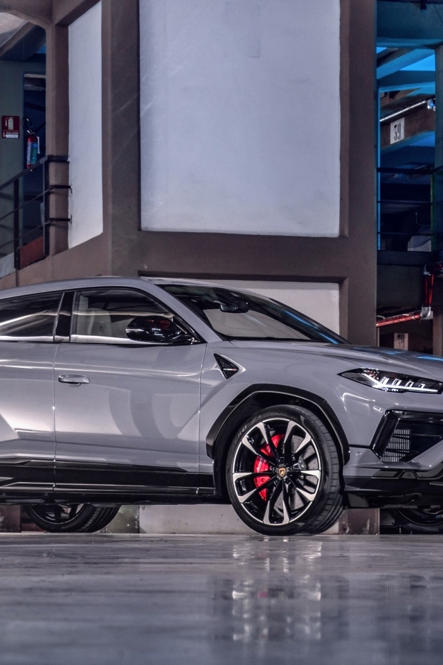 Серебристый автомобиль Lamborghini Urus S в здании