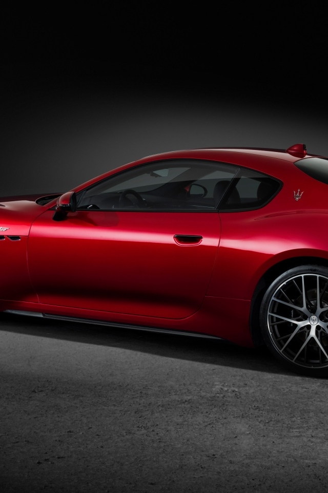 Красный автомобиль Maserati GranTurismo Trofeo 2023 на сером фоне