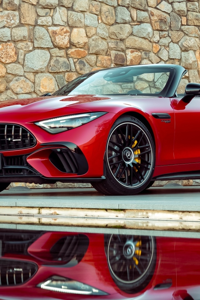 Красный Mercedes-AMG SL 63 4MATIC+ 2023 года на фоне стены
