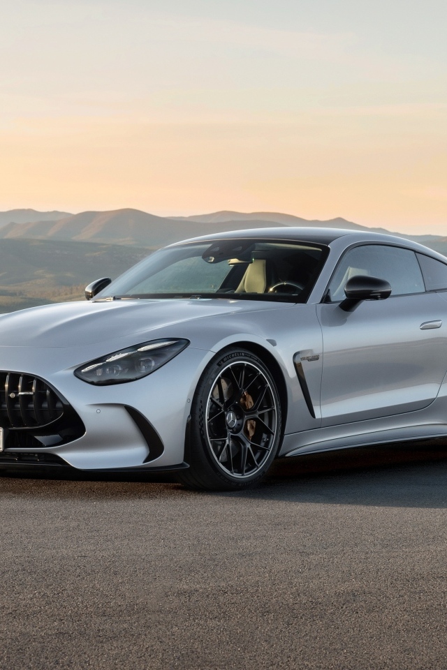 Серебристый автомобиль Mercedes-AMG GT 63 4MATIC+ 2023 года на фоне гор