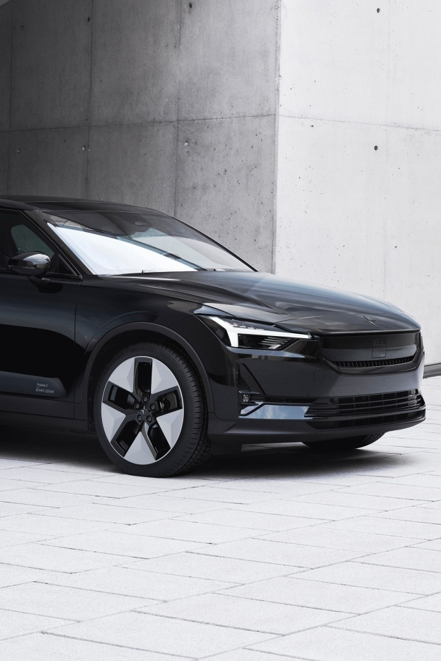 Черный автомобиль Polestar 2 2023 года у серой стены