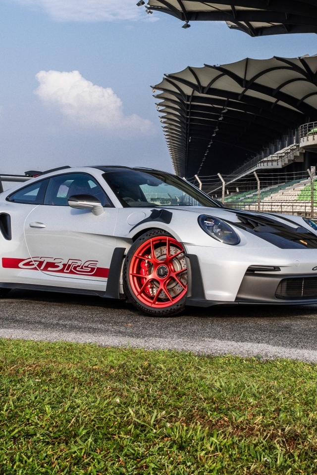 Гоночный автомобиль Porsche 911 GT3 RS Weissach Package 2023 года на трассе