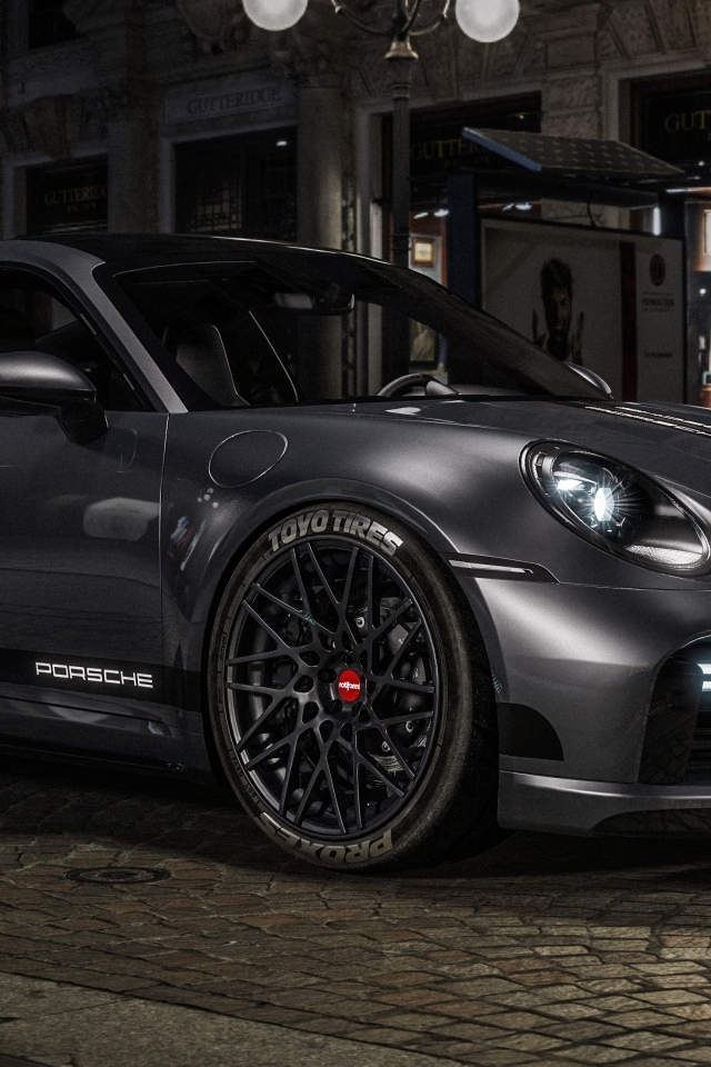 Быстрый автомобиль Porsche 911 Turbo S у здания