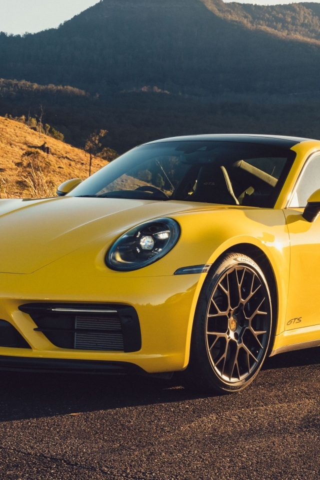 Желтый быстрый автомобиль Porsche 911 Carrera GTS вид спереди