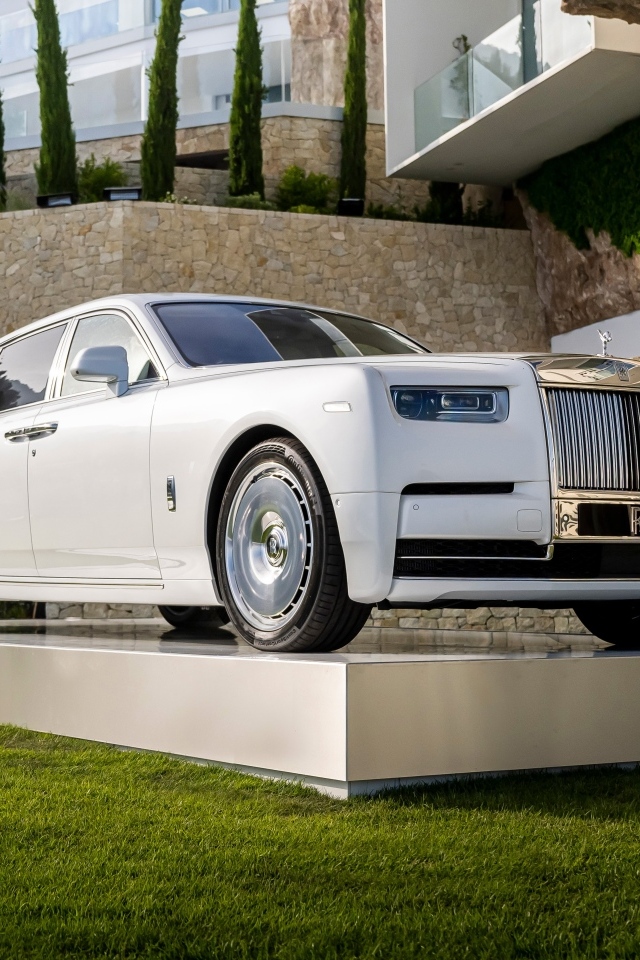 Белый автомобиль Rolls-Royce Phantom 2022 года у дома