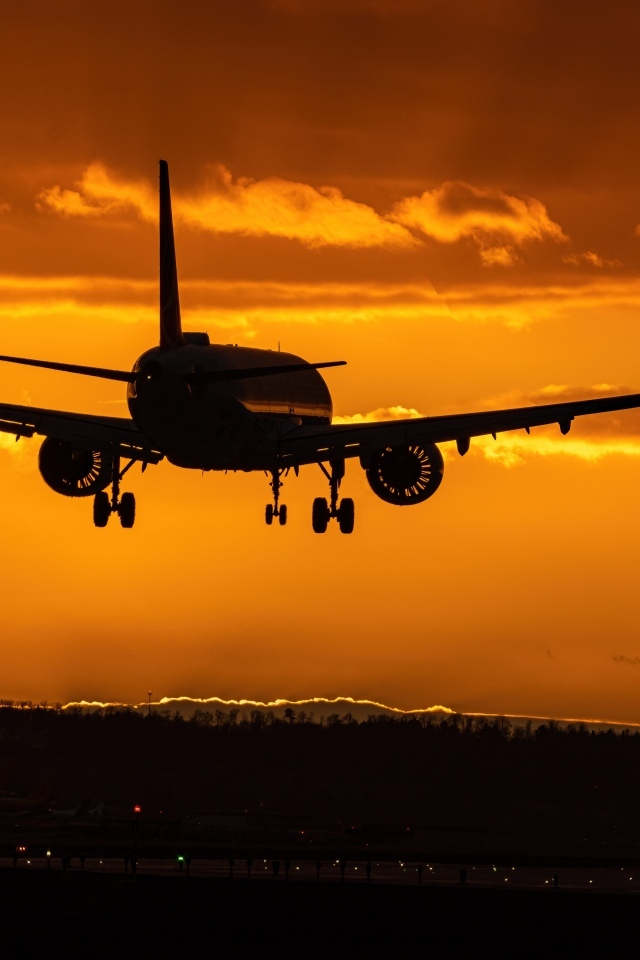 Самолет идет на посадку на закате 