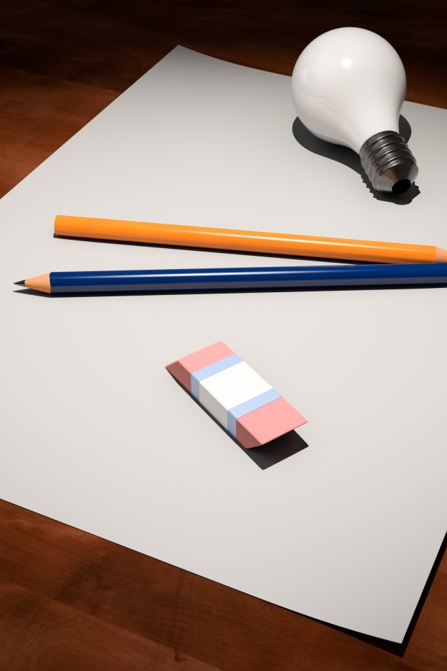 Лист бумаги, карандаши, ластик и лампочка на столе