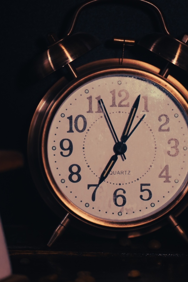 Большой будильник показывает семь часов