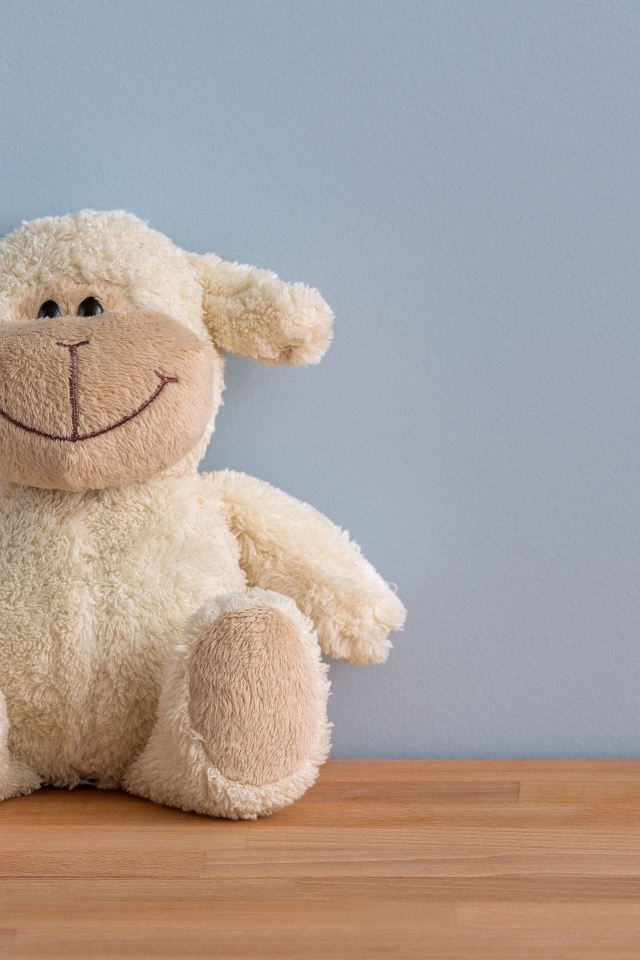 Детская игрушка на полу у серой стены