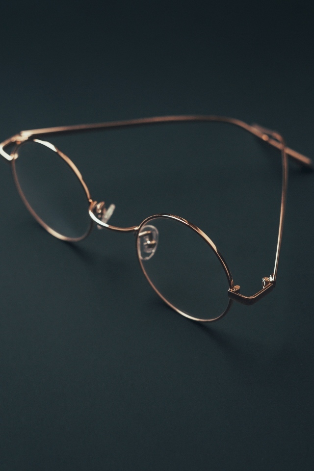 Очки лежат на серой поверхности