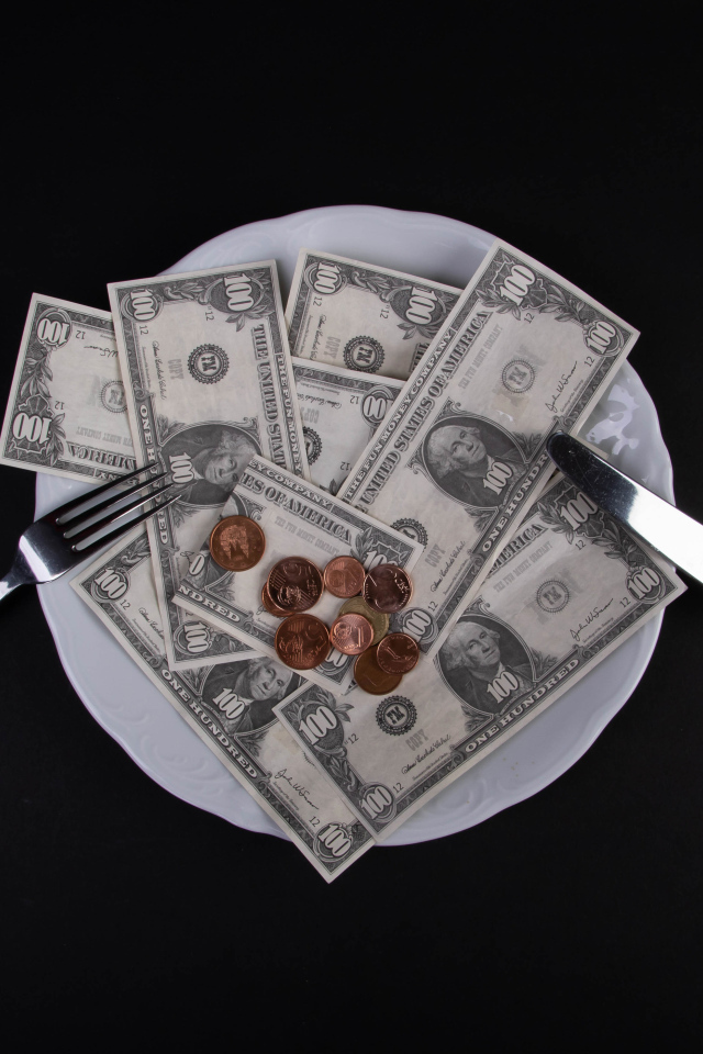 Тарелка с долларами на черном фоне