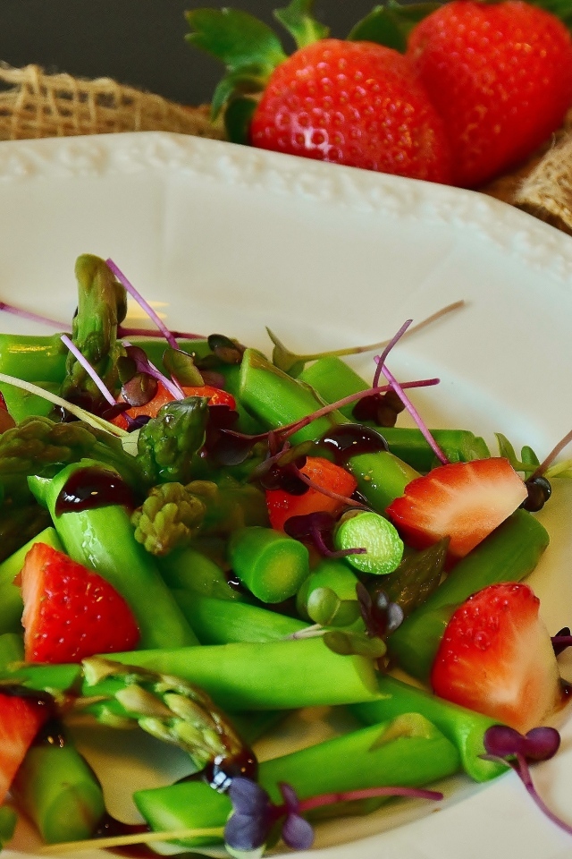 Спаржа в тарелке с клубникой