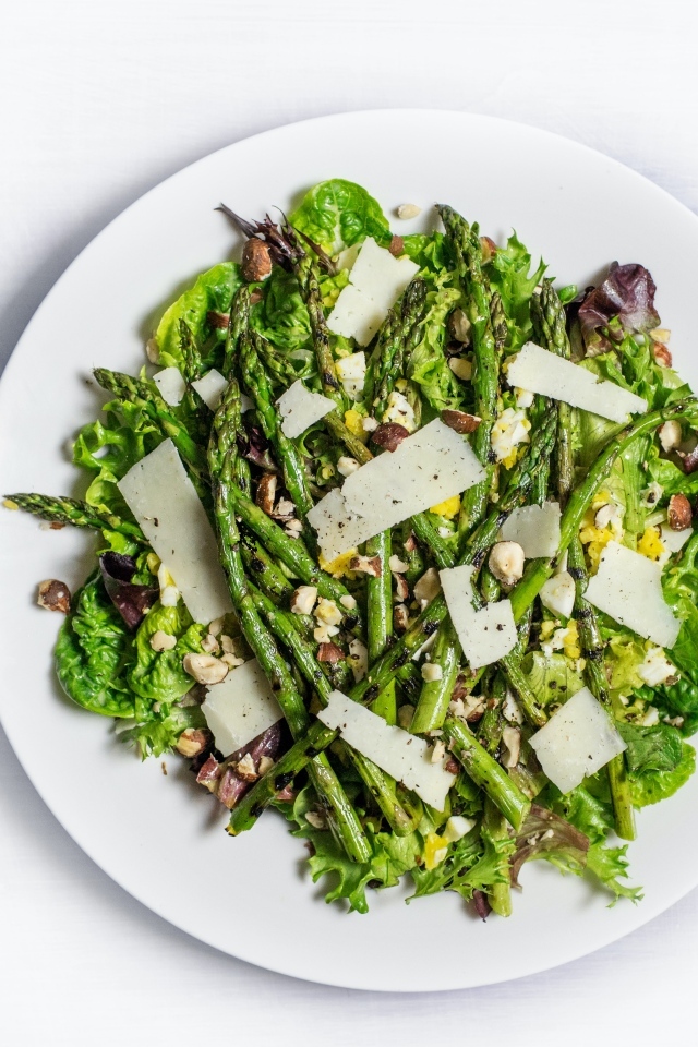 Спаржа на белой тарелке с сыром