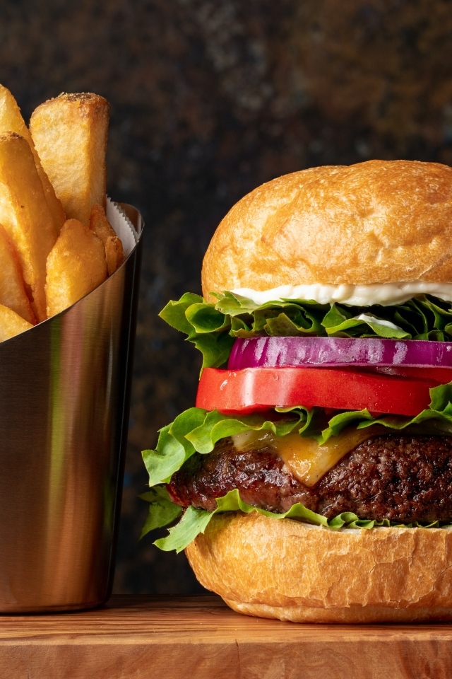 Большой гамбургер на столе с картофелем фри