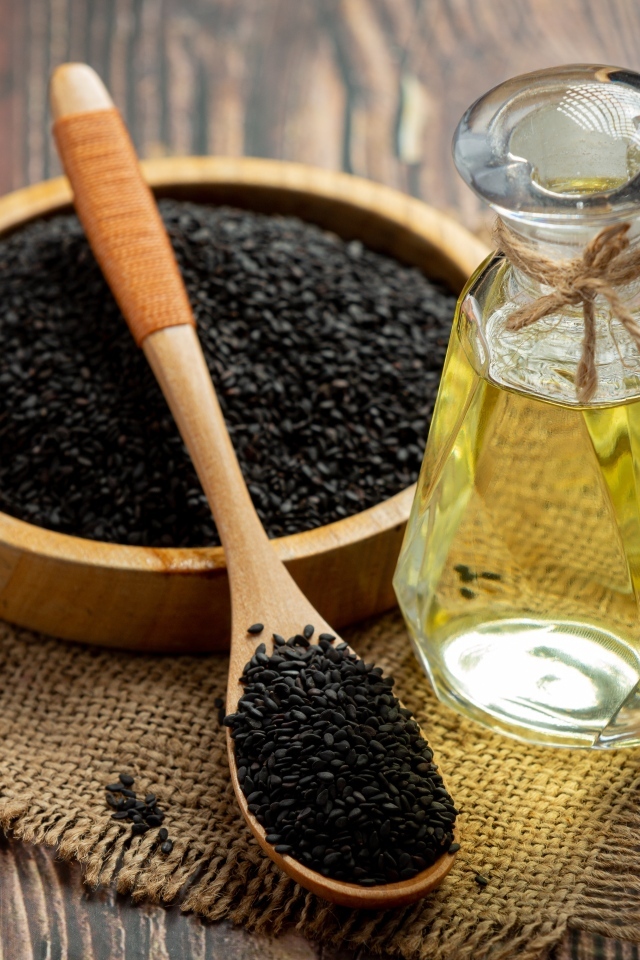 Черные семена на столе с маслом