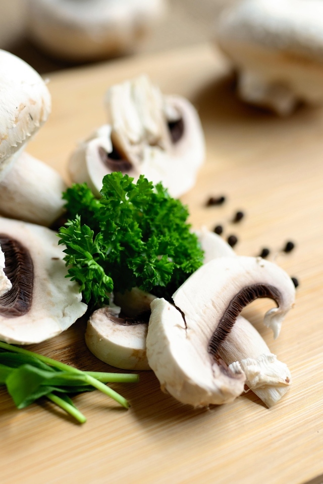 Шампиньоны с петрушкой на разделочной доске