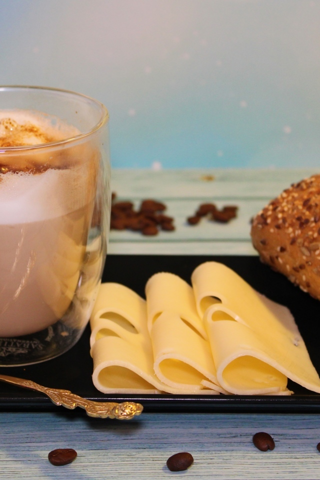 Сыр на тарелке с какао и булочкой