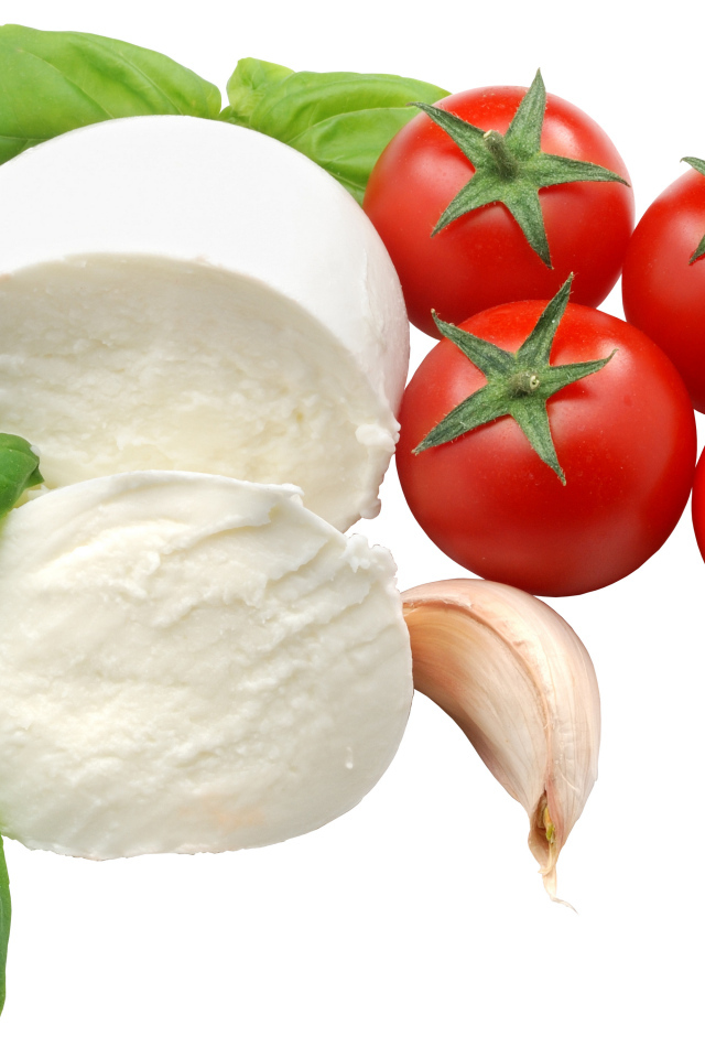 Сыр на белом фоне с помидорами, листьями базилика и чесноком