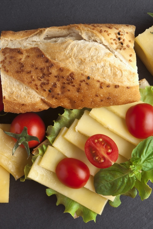 Сыр с батоном и помидорами на столе