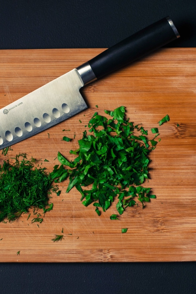 Нарезанная зелень на доске с ножом