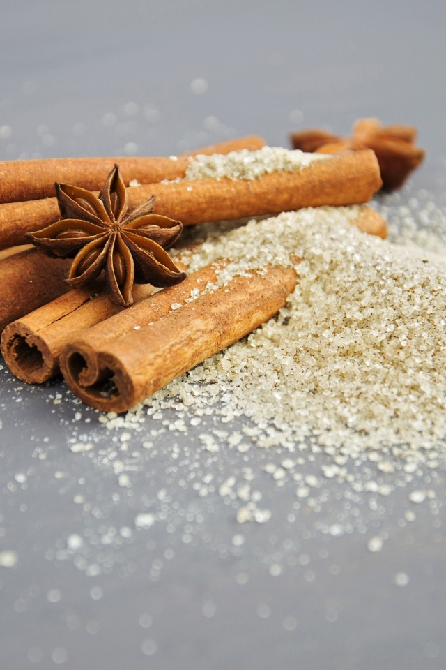 Корица, коричневый сахар и бадьян на сером фоне