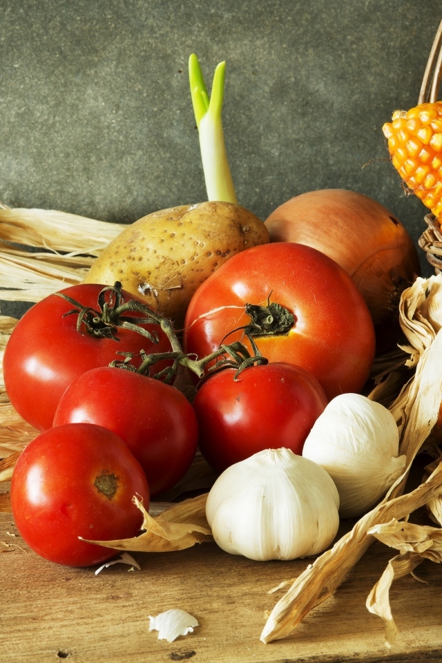 Кукуруза, чеснок и помидоры на столе