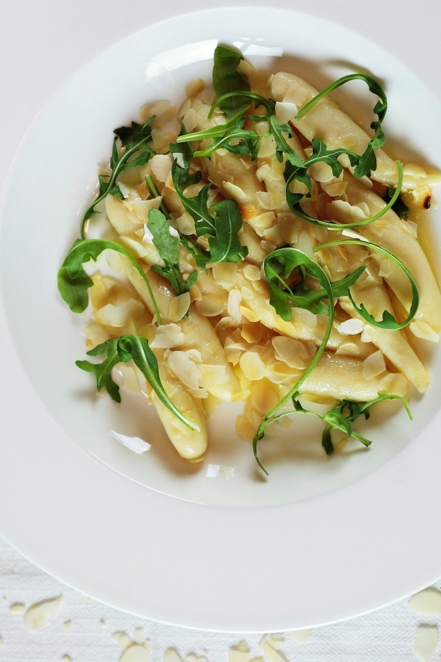 Блюдо с листьями рукколы в большой белой тарелке