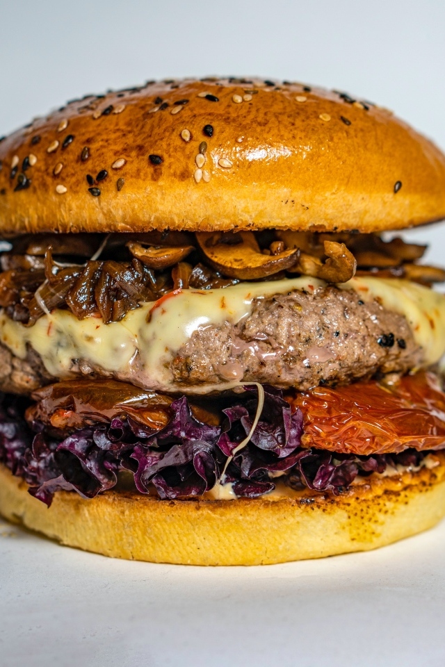 Ароматный сочный гамбургер на сером фоне крупным планом