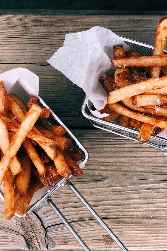 Картофель фри в сетке на столе