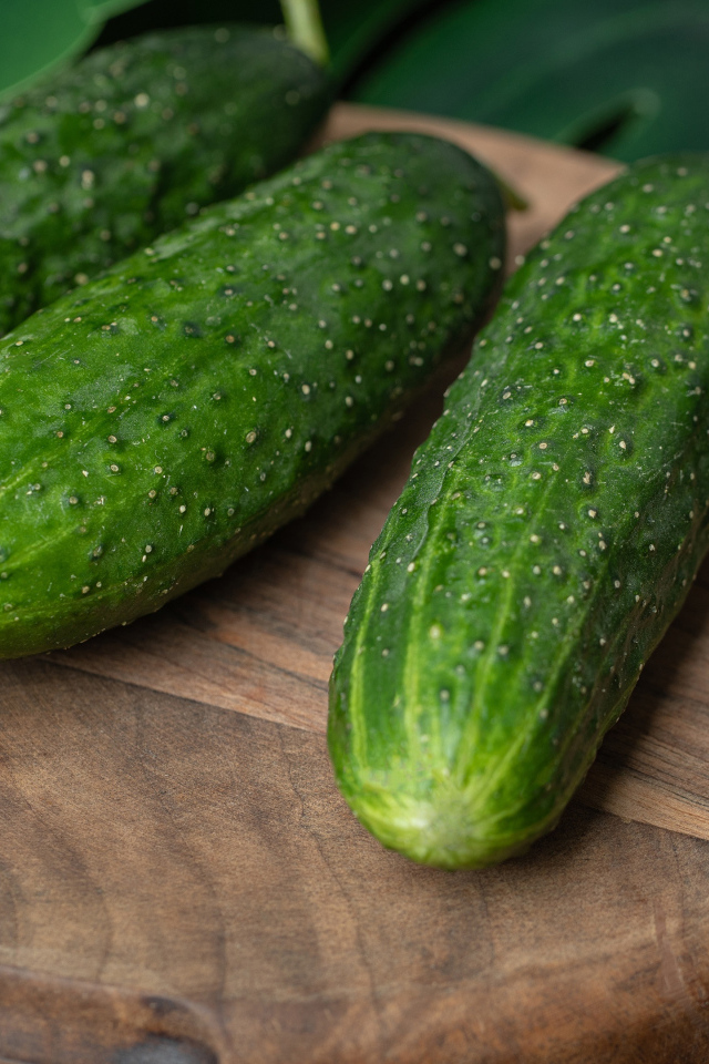 Свежие зеленые огурцы на деревянной доске