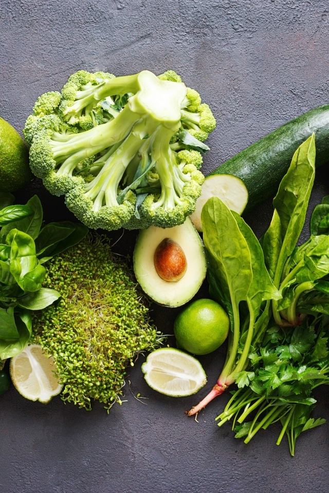 Свежие зеленые овощи на сером столе
