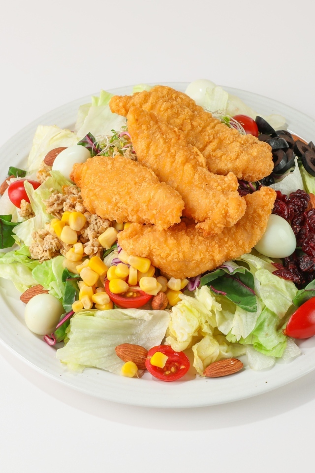 Салат с жареной курицей на сером фоне