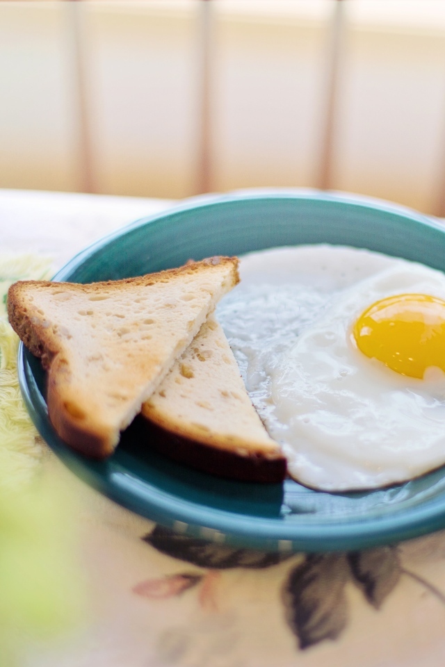 Яичница с хлебом на столе на завтрак 