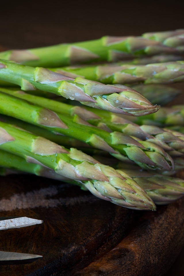 Зеленые стебли спаржи на столе