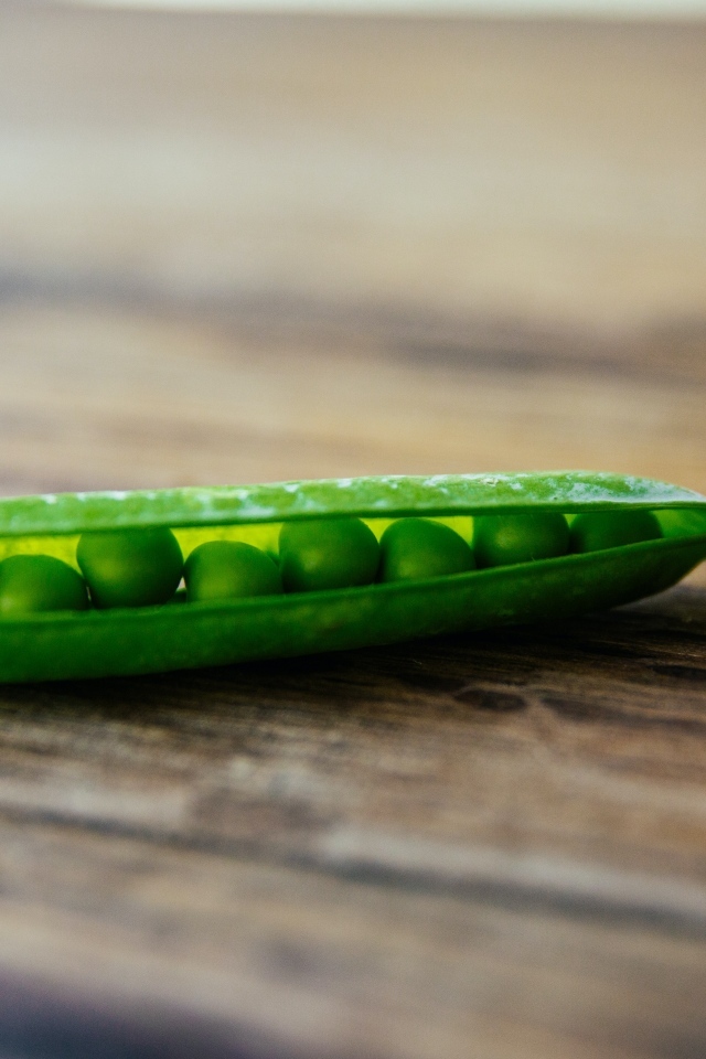 Зеленый горох на деревянном столе